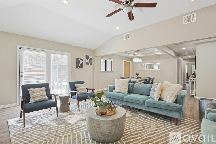 A living room with a blue couch and a ceiling fan.