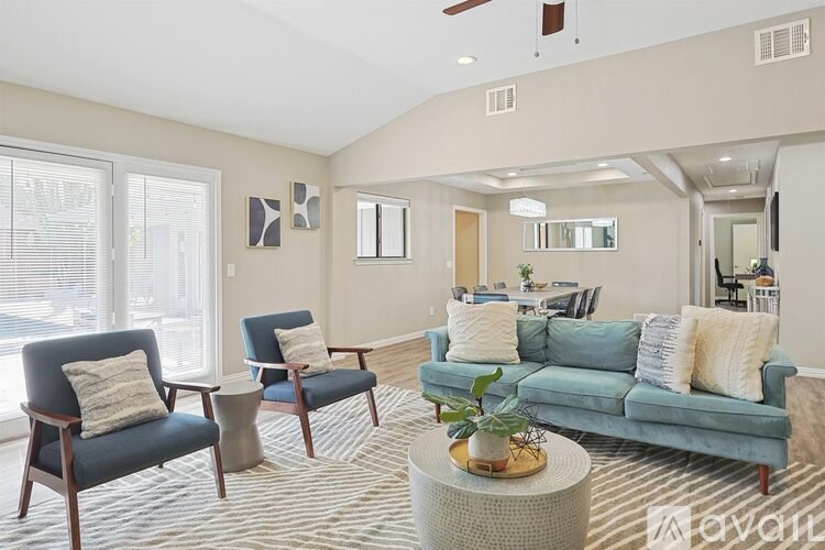 A living room with a blue couch and two chairs.