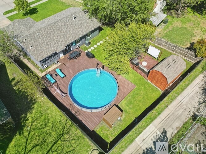 An aerial view of a house with a blue pool in the backyard.