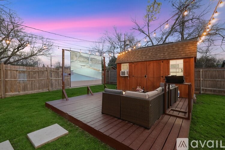 A backyard with a wooden deck and a screened-in area.