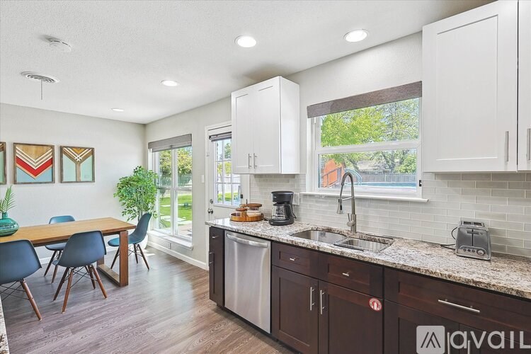 A kitchen with brown cabinets and a wooden table with chairs.