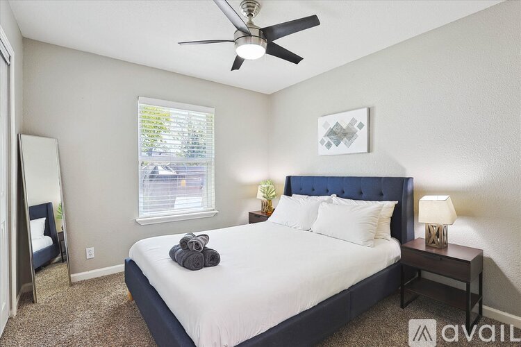 A bedroom with a bed, nightstand, and window.