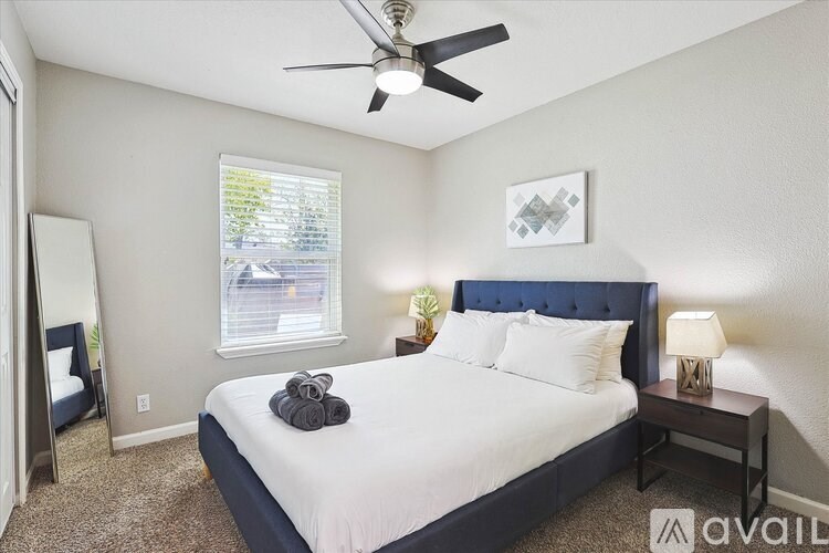 A bedroom with a bed, nightstand, and window.