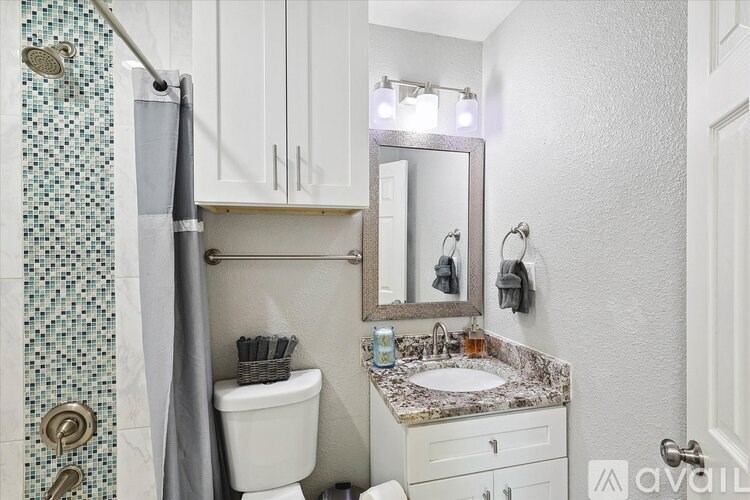 A bathroom with a sink, toilet, and shower.