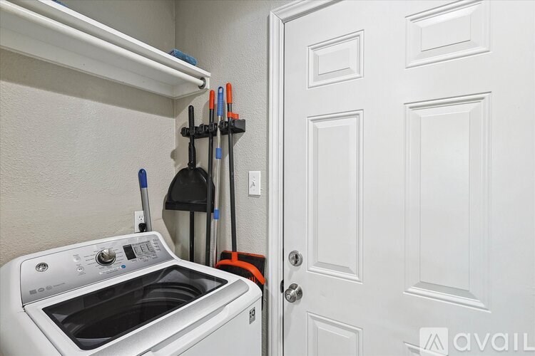 A white oven with a black door sits next to a white door.