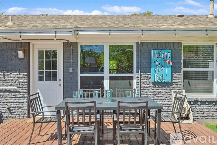 A patio with a table and chairs is set up outside a house.