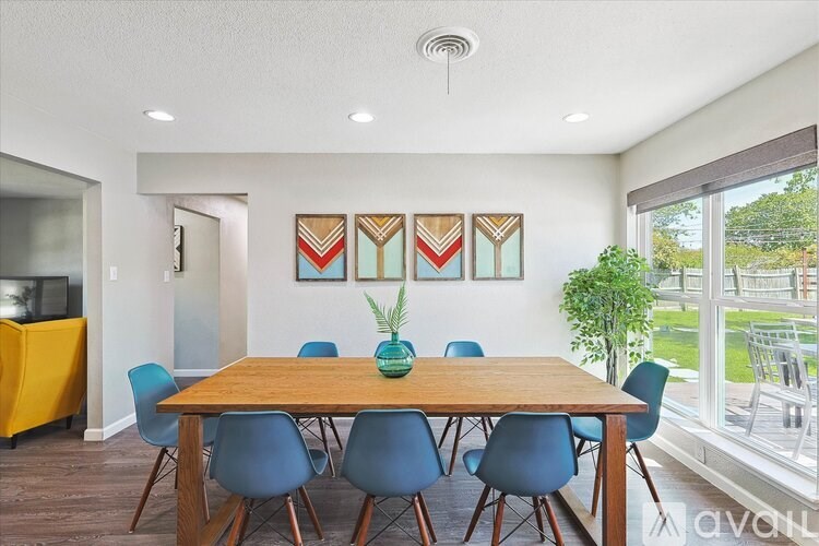 A dining room with a wooden table and blue chairs.