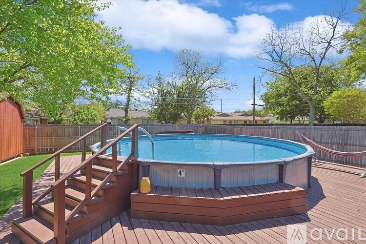 A small above ground pool with a wooden deck and stairs.
