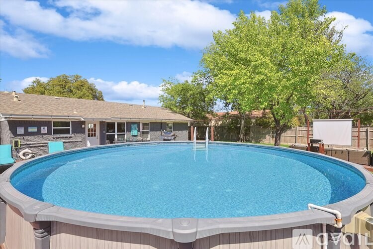 A small pool in a backyard with a tree in the background.
