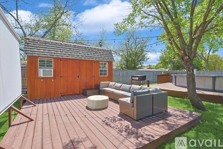 A wooden deck with a hot tub and a small wooden building.