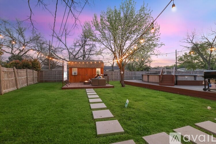 A backyard with a wooden shed and a stone pathway leading to it.
