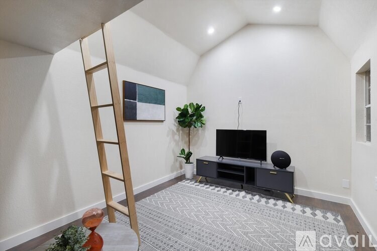 A room with a television and a ladder.