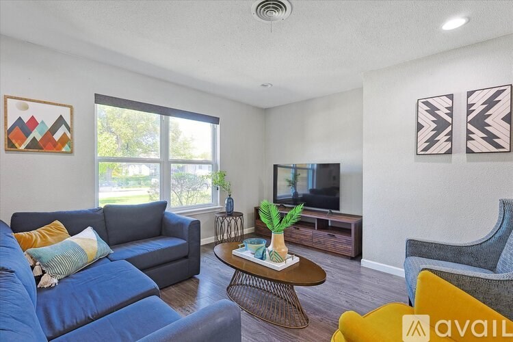 A living room with a blue couch, a coffee table, and a television.