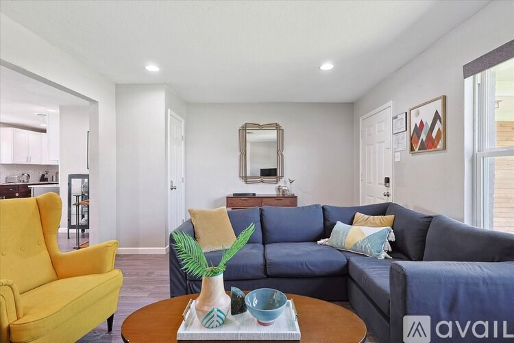 A living room with a yellow chair and a blue couch.