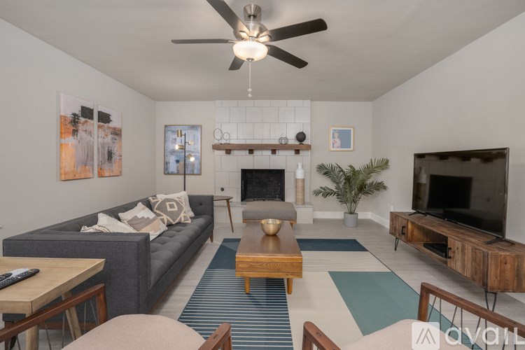 A living room with a grey couch, a coffee table, a fireplace, and a television.