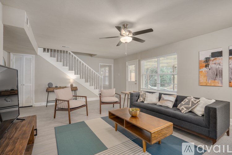 A living room with a staircase and a television.