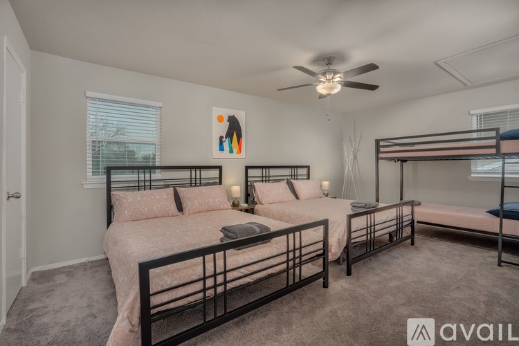 A bedroom with two beds and a ceiling fan.