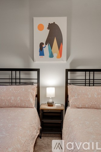 Two twin beds with a bear painting on the wall.