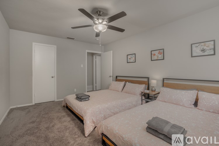 A bedroom with two beds and a ceiling fan.