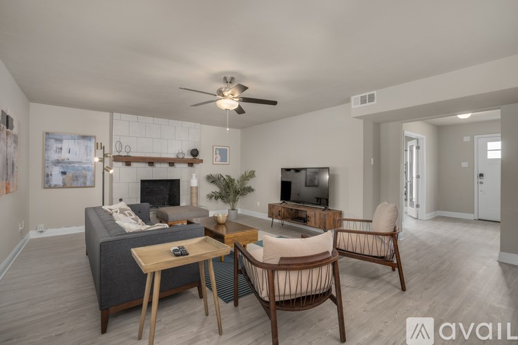 A living room with a grey couch, a wooden table, and a television.