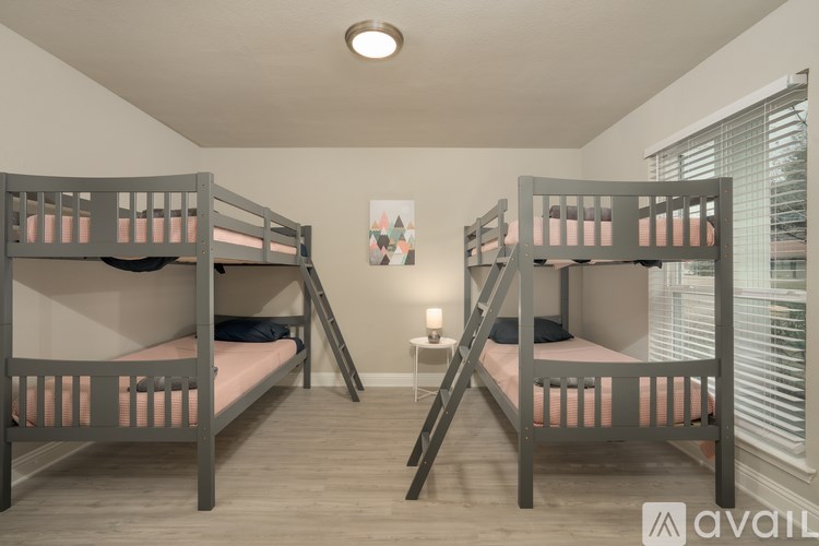 Two bunk beds in a room with wooden floors and a painting on the wall.