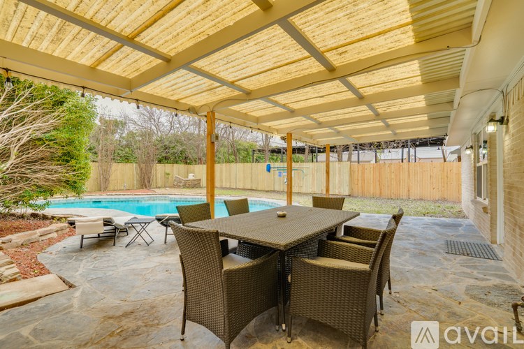 A patio with a table and chairs and a pool.
