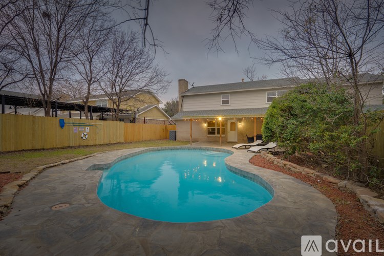 A pool in a backyard with a house in the background.