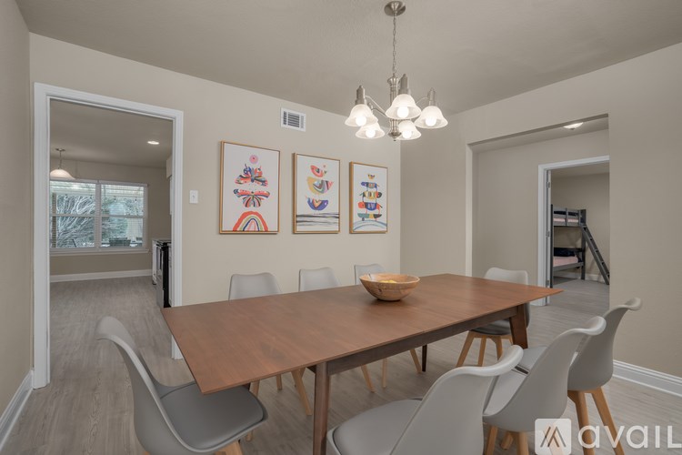 A dining room with a wooden table and chairs.