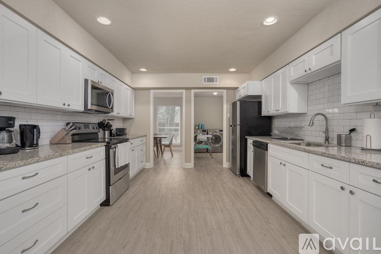 A kitchen with white cabinets and a wooden floor.
