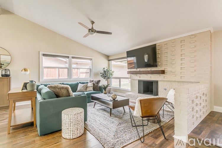 A living room with a green couch, a fireplace, and a television.