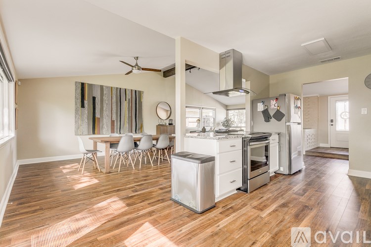 A kitchen with a wooden floor and white appliances.