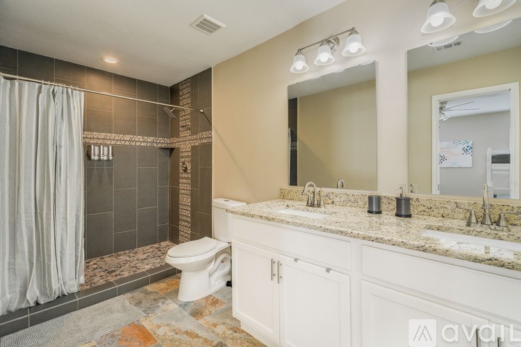 A bathroom with a toilet, sink, and shower area.