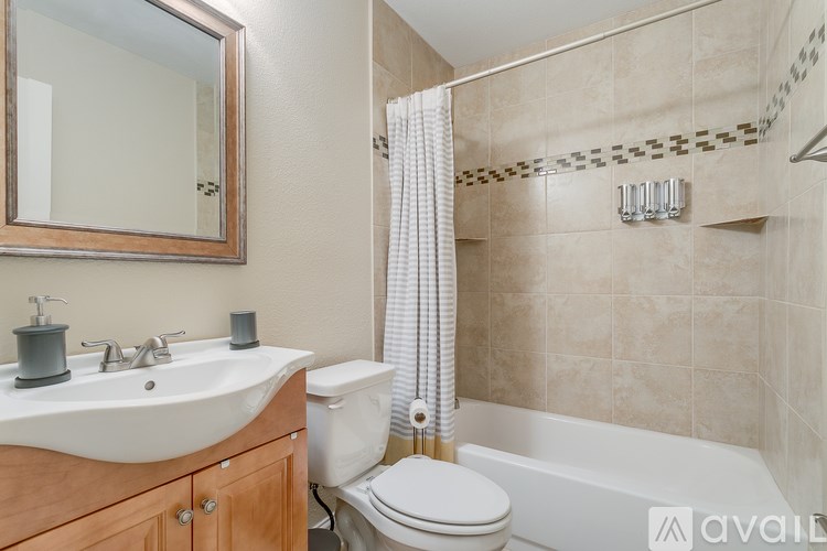 A bathroom with a white toilet, a sink with a mirror above it, and a bathtub.