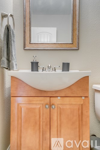 A bathroom with a wooden medicine cabinet and a mirror above it.