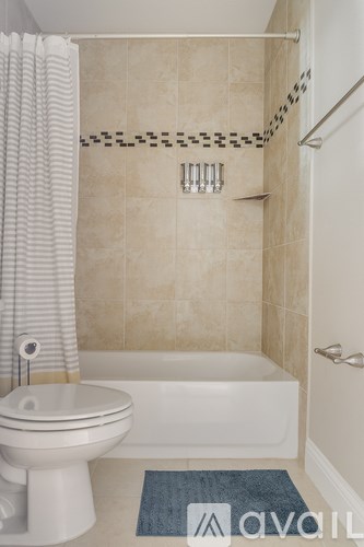 A bathroom with a white toilet and a white bathtub.