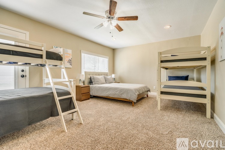 A bedroom with two bunk beds and a single bed.