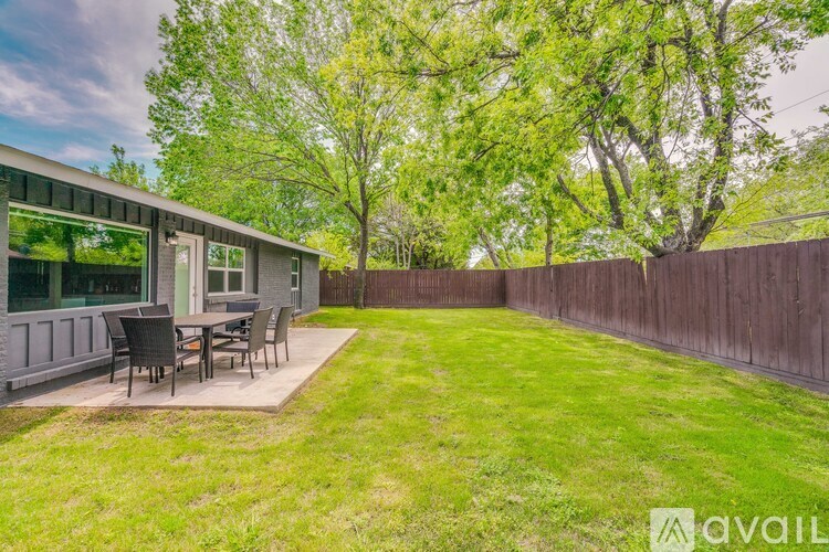 A backyard with a wooden fence and a patio table.