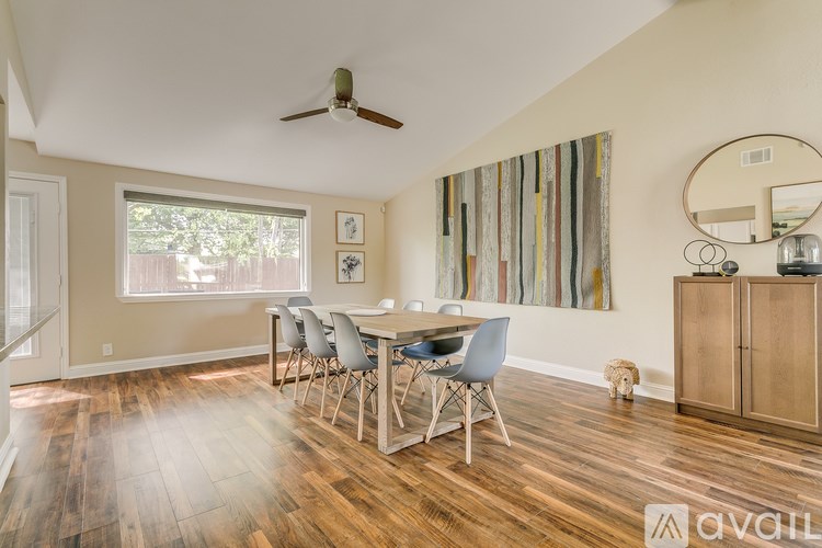 A dining room with a wooden table and chairs.