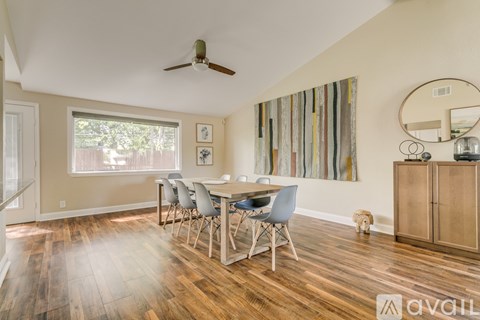 A dining room with a wooden table and chairs.