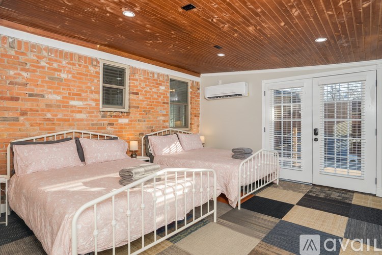 Two twin beds in a room with brick walls.