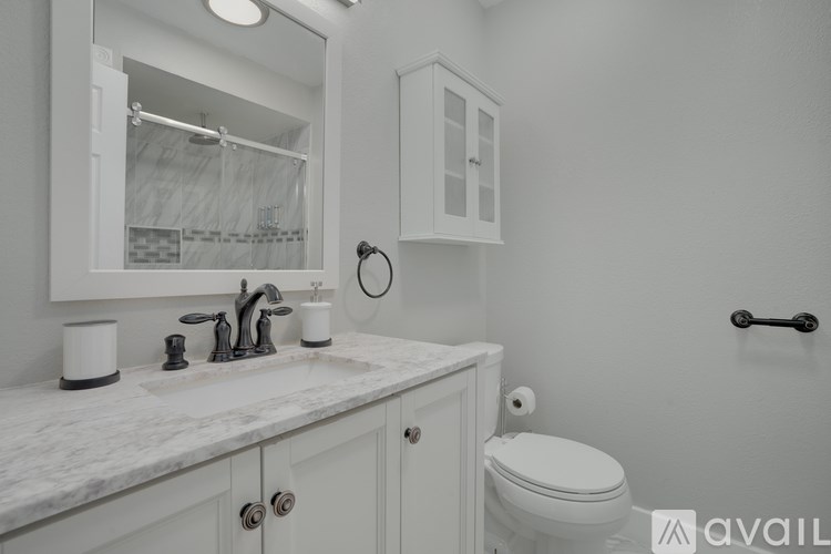 A bathroom with a white toilet and a marble countertop.
