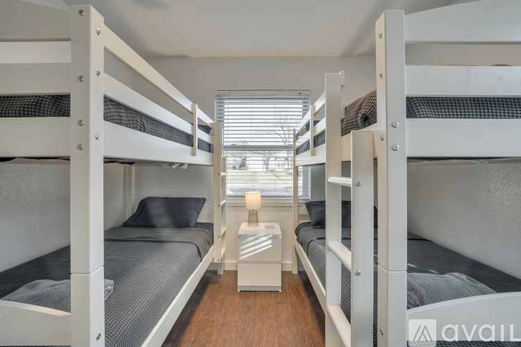 A room with bunk beds and a small table in between.