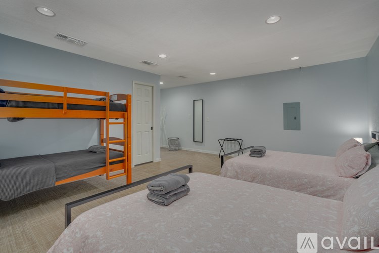 A bedroom with two beds and a bunk bed.