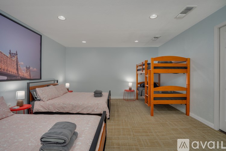 A bedroom with two beds and a large picture on the wall.