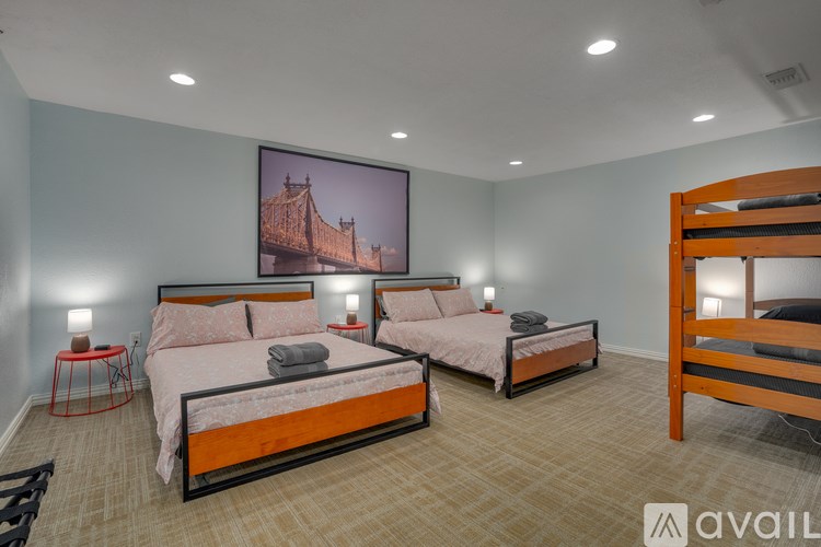 A bedroom with two beds and a large painting of a bridge on the wall.