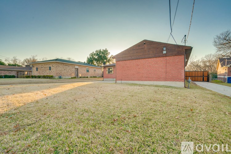 A red brick building with a grassy yard in front.