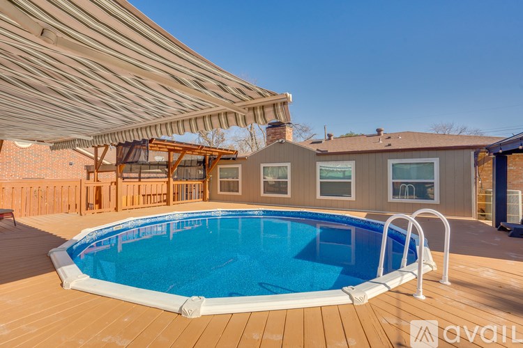 A pool with a wooden deck and a patio umbrella.