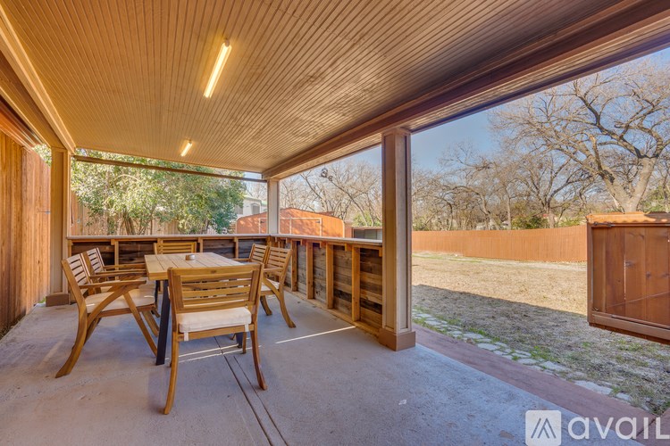 A wooden table and chairs are set up on a patio.