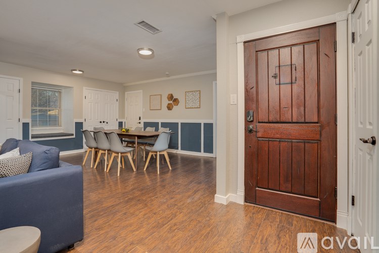 A living room with a blue couch and a wooden door.