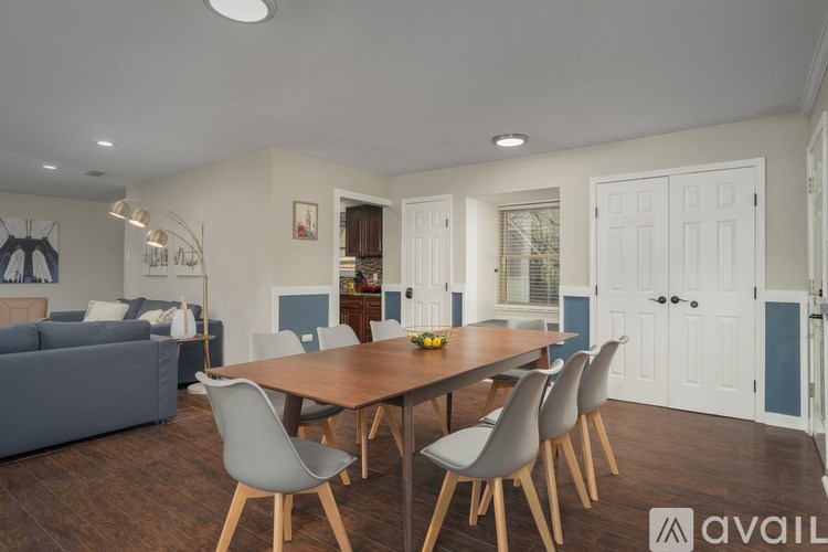 A modern dining room with a wooden table and grey chairs.